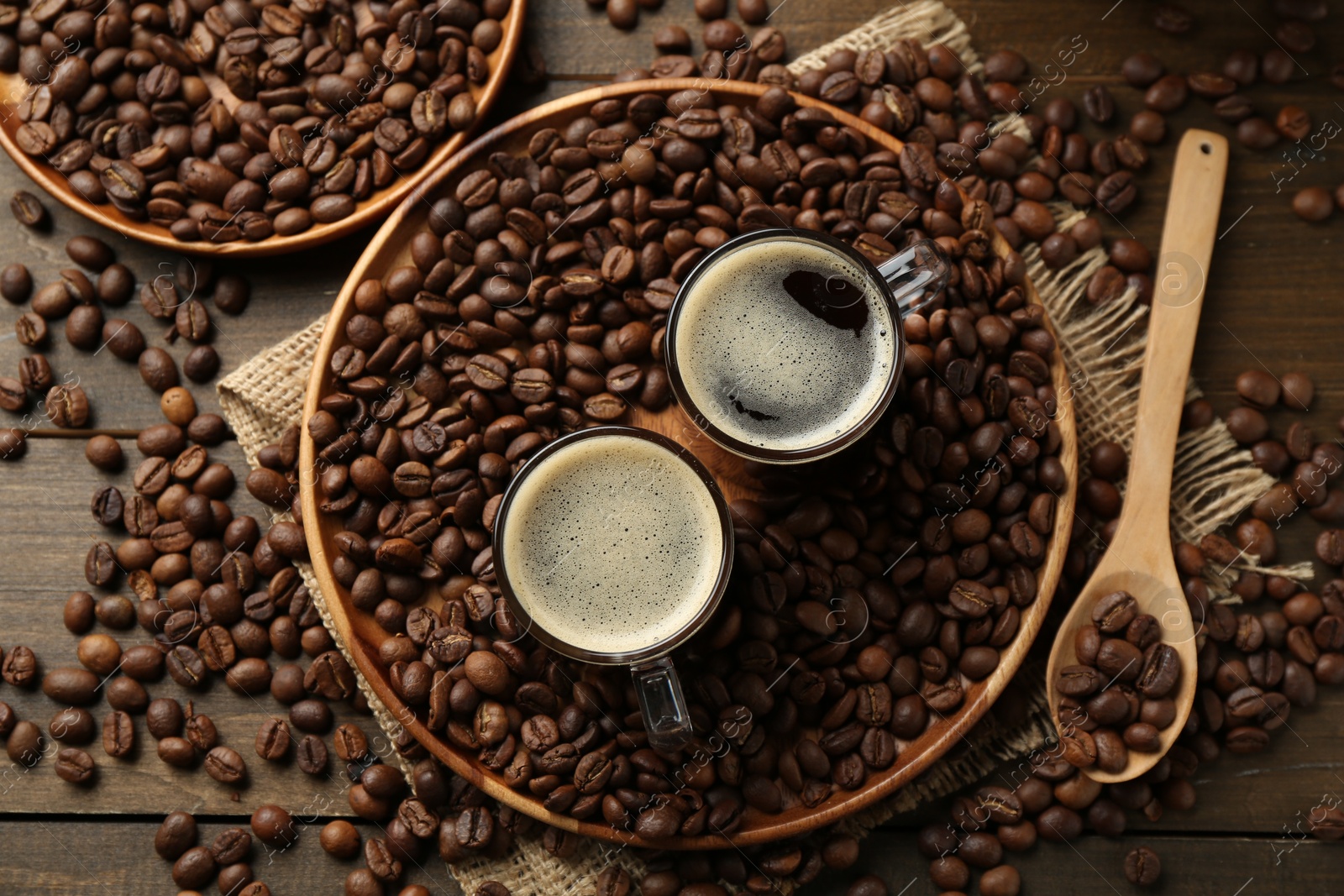Aromatic coffee in cups and beans on table, flat lay Photo of Aromatic coffee in cups and beans on table, flat lay