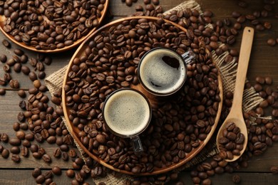 Photo of Aromatic coffee in cups and beans on table, flat lay