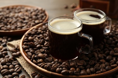 Photo of Aromatic coffee in cups and beans on table, closeup