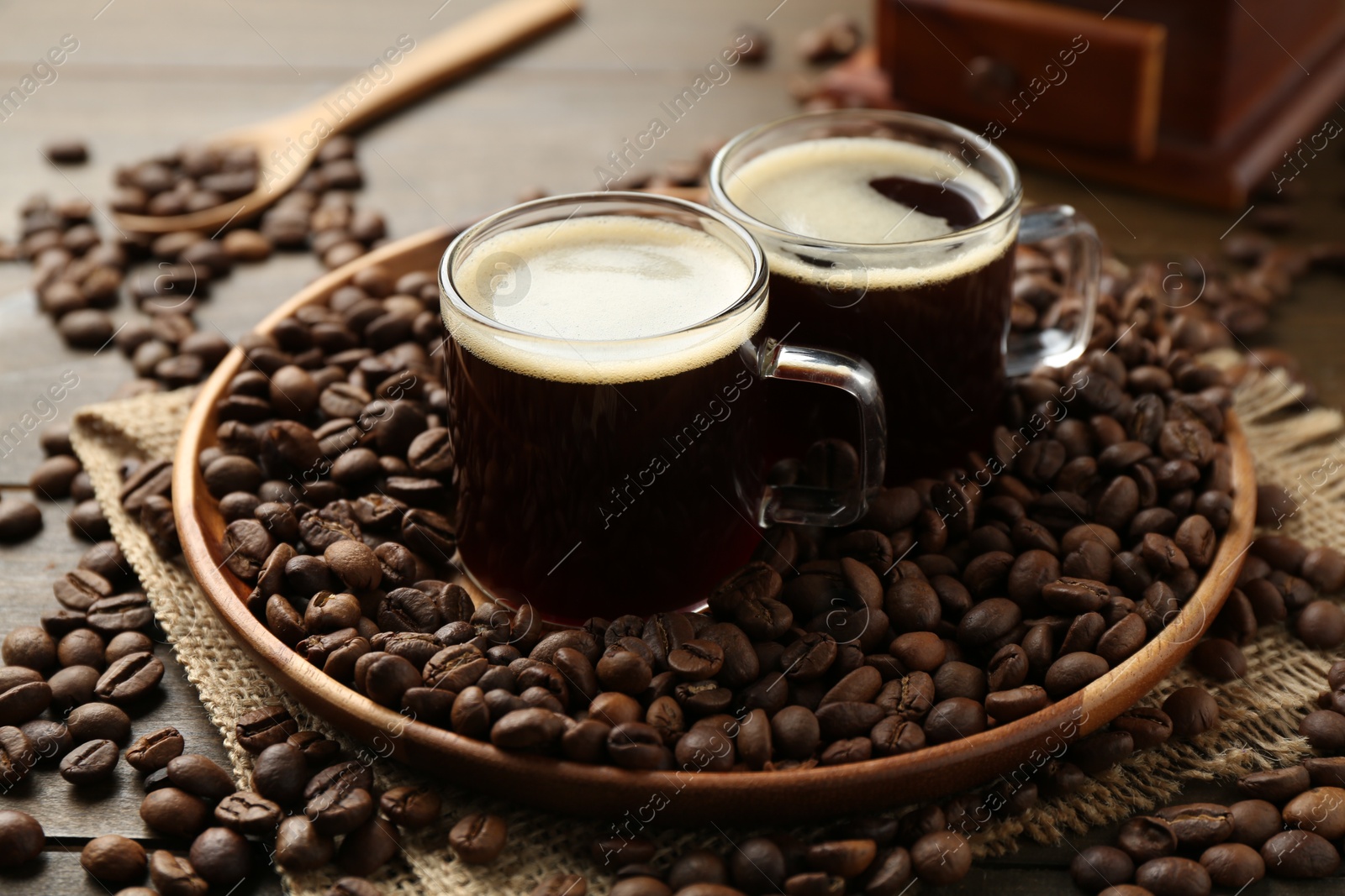 Aromatic coffee in cups and beans on wooden table, closeup Photo of Aromatic coffee in cups and beans on wooden table, closeup