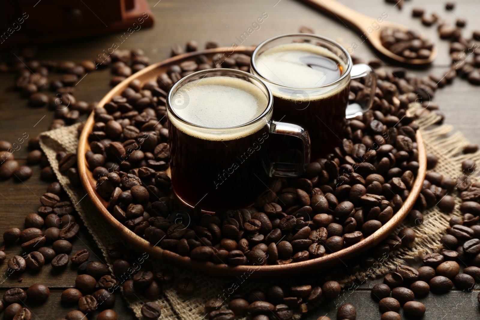 Aromatic coffee in cups and beans on wooden table, closeup Photo of Aromatic coffee in cups and beans on wooden table, closeup