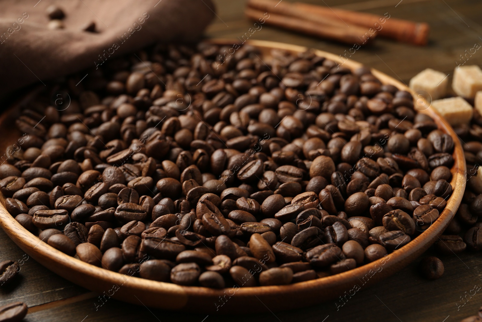 Aromatic coffee beans, brown sugar and cinnamon on table, closeup Photo of Aromatic coffee beans, brown sugar and cinnamon on table, closeup