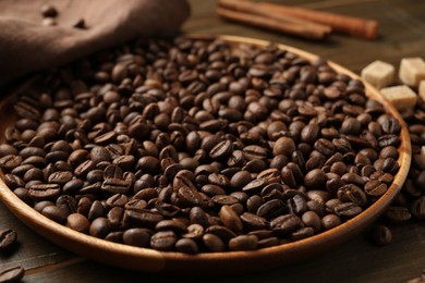 Photo of Aromatic coffee beans, brown sugar and cinnamon on table, closeup