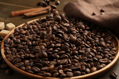 Photo of Pouring coffee beans onto plate at table, closeup
