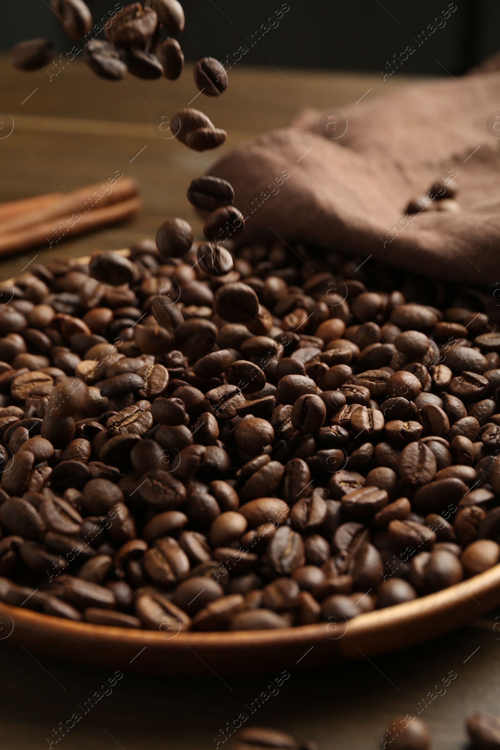 Pouring coffee beans onto plate at table, closeup Photo of Pouring coffee beans onto plate at table, closeup