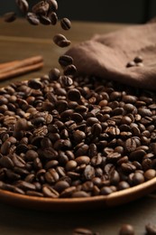 Photo of Pouring coffee beans onto plate at table, closeup