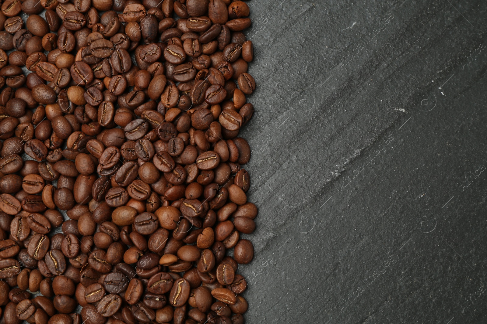 Aromatic coffee beans on black table, flat lay. Space for text Photo of Aromatic coffee beans on black table, flat lay. Space for text