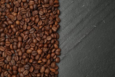 Photo of Aromatic coffee beans on black table, flat lay. Space for text