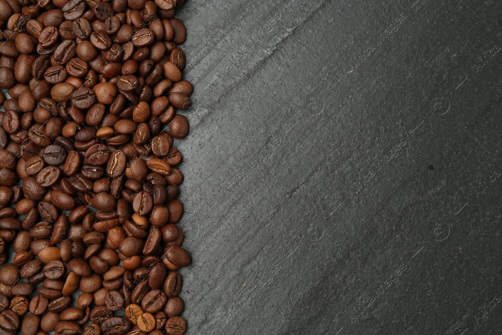 Aromatic coffee beans on black table, flat lay. Space for text Photo of Aromatic coffee beans on black table, flat lay. Space for text