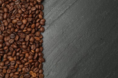 Photo of Aromatic coffee beans on black table, flat lay. Space for text