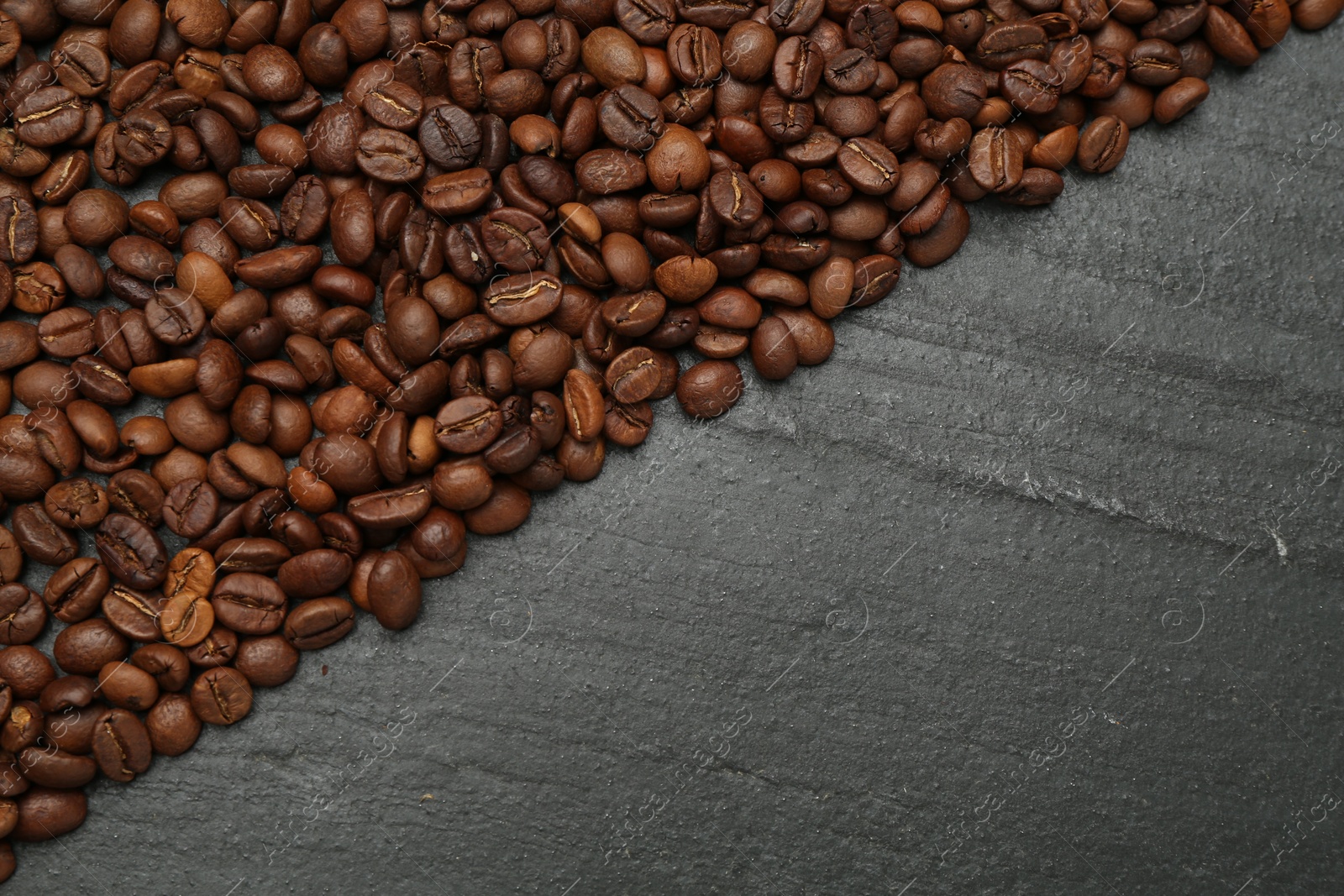 Aromatic coffee beans on black table, flat lay. Space for text Photo of Aromatic coffee beans on black table, flat lay. Space for text