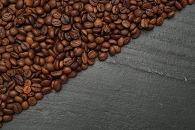 Photo of Aromatic coffee beans on black table, flat lay. Space for text