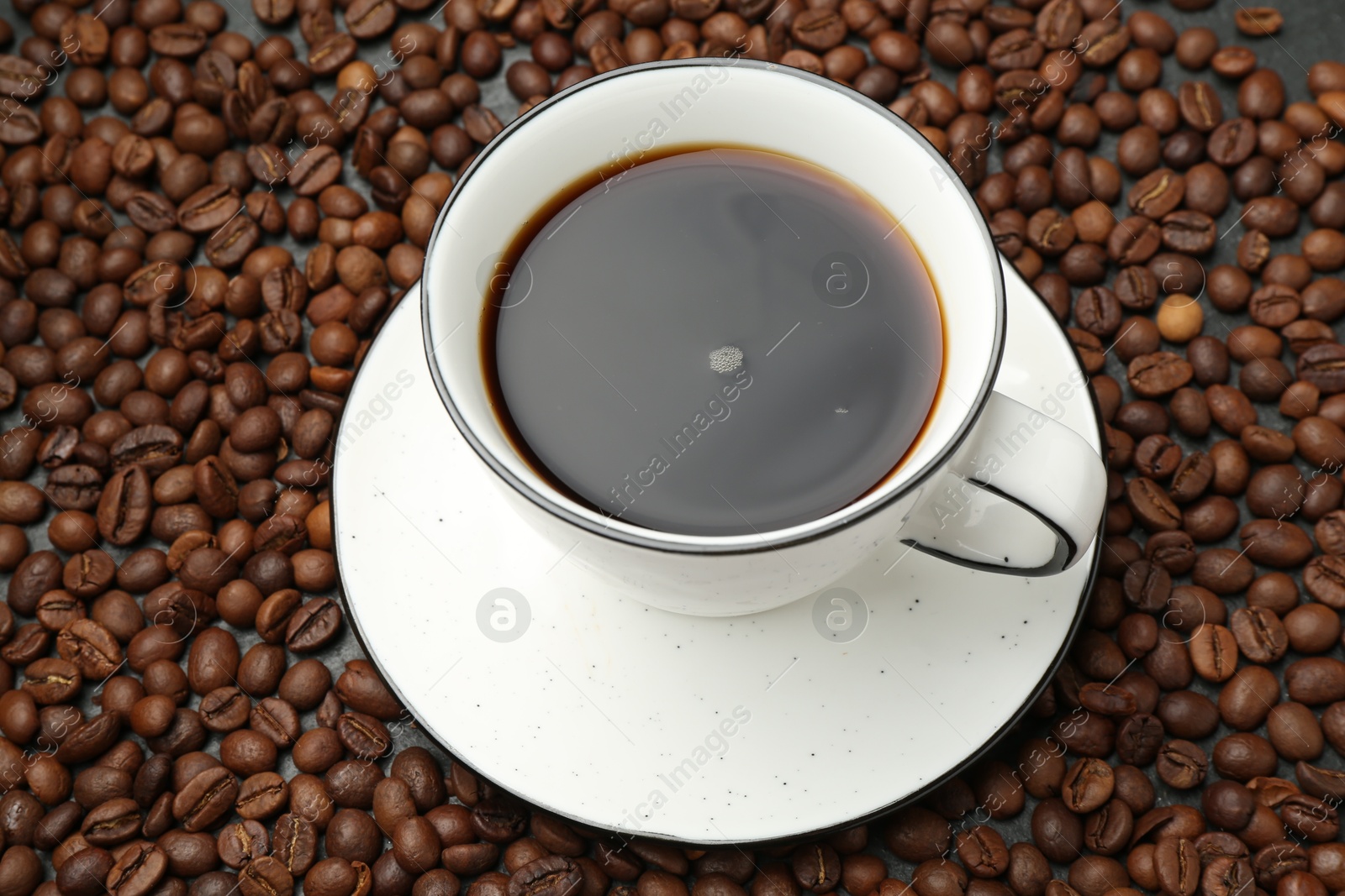 Aromatic coffee in cup on beans, above view Photo of Aromatic coffee in cup on beans, above view