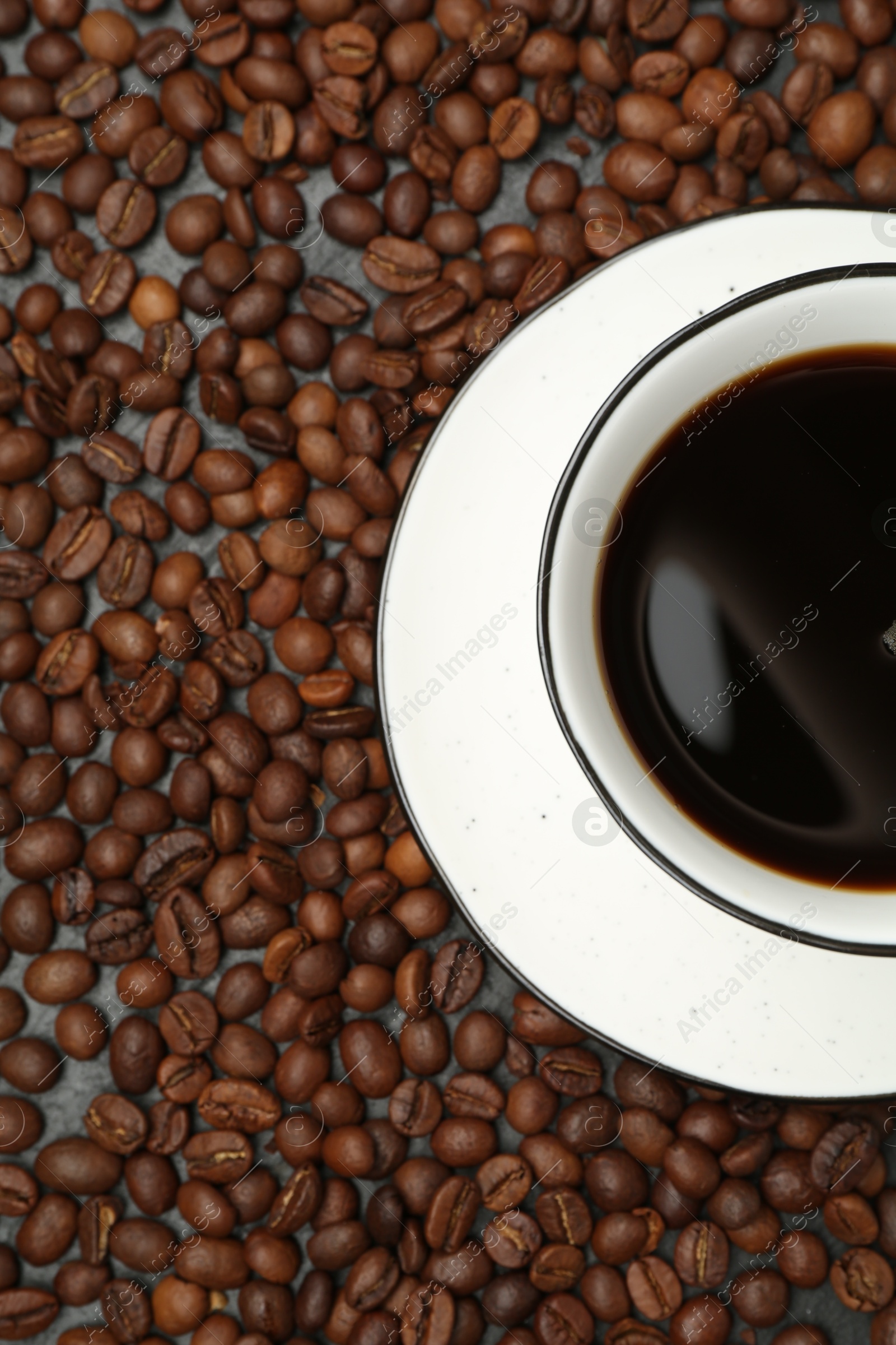 Aromatic coffee in cup on beans, top view Photo of Aromatic coffee in cup on beans, top view
