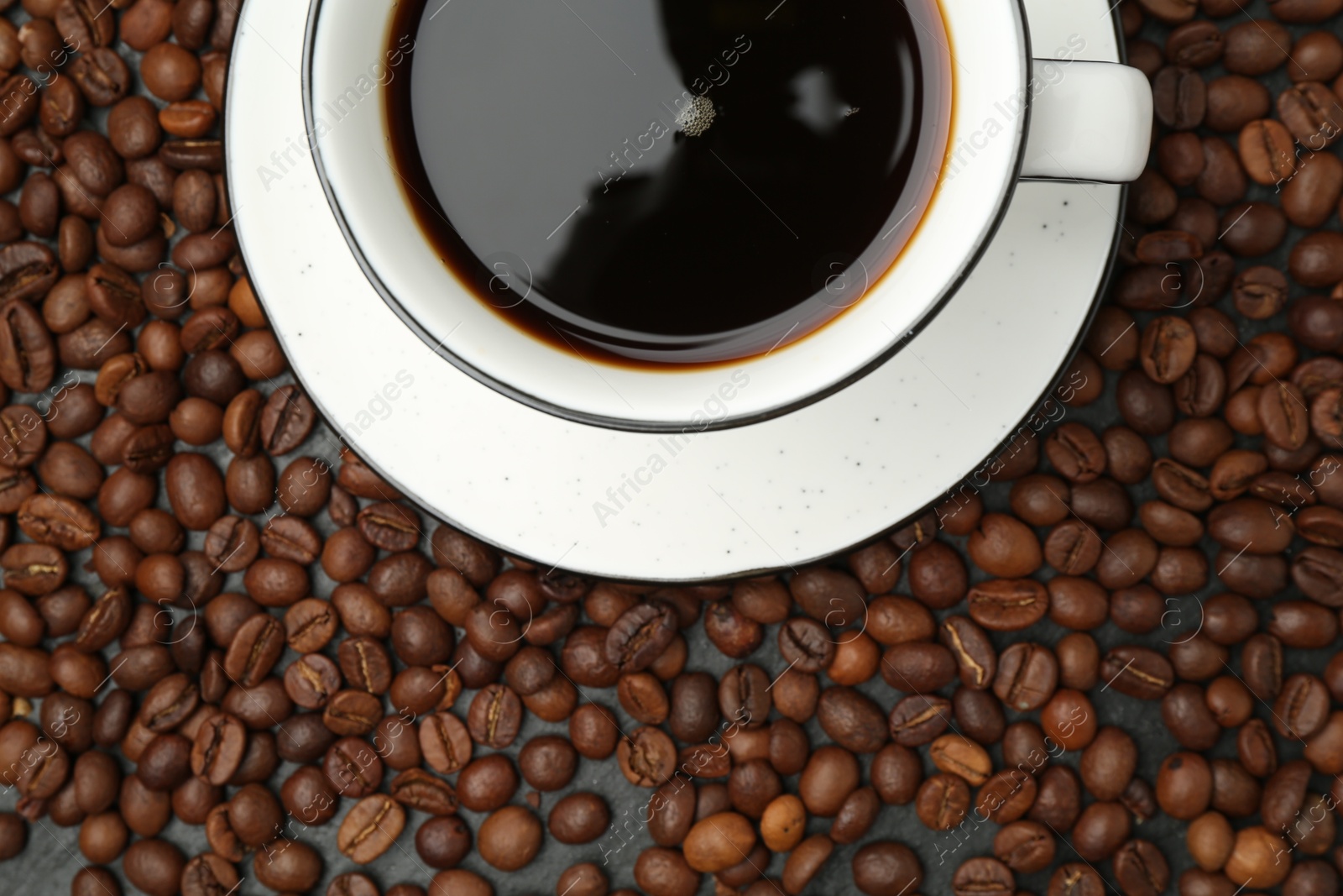 Aromatic coffee in cup on beans, top view Photo of Aromatic coffee in cup on beans, top view