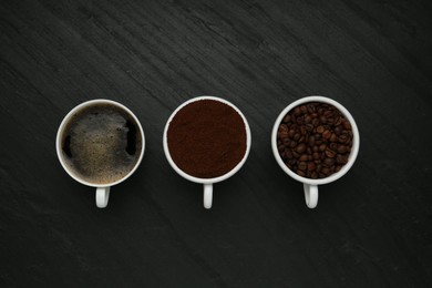 Photo of Aromatic ground coffee, beans and hot drink on black table, flat lay