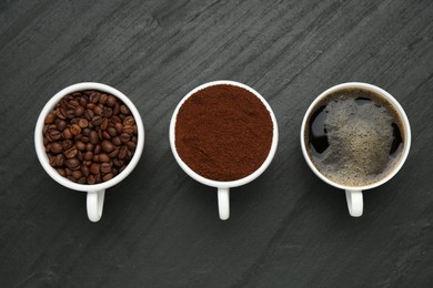 Photo of Aromatic ground coffee, beans and hot drink on black table, flat lay