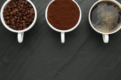 Photo of Aromatic ground coffee, beans and hot drink on black table, flat lay. Space for text