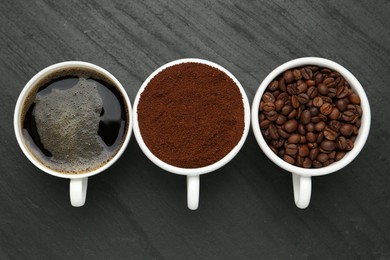 Photo of Aromatic ground coffee, beans and hot drink on black table, flat lay