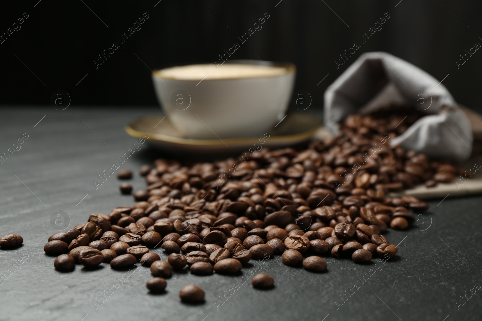 Aromatic coffee beans and hot drink on black table, closeup Photo of Aromatic coffee beans and hot drink on black table, closeup