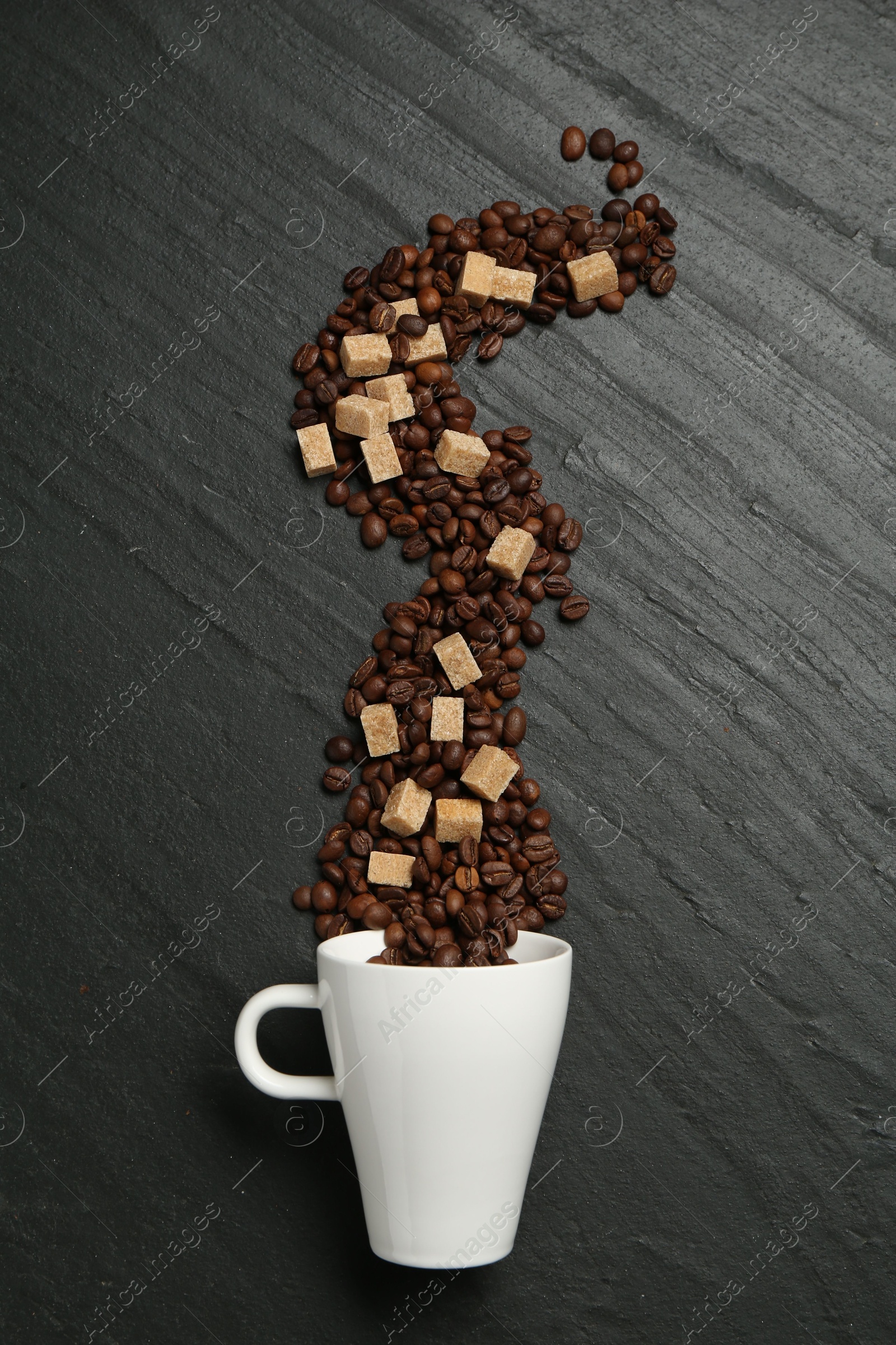 Aromatic coffee beans, brown sugar and cup on black table, flat lay Photo of Aromatic coffee beans, brown sugar and cup on black table, flat lay