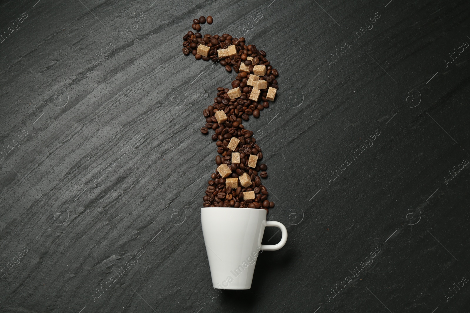 Aromatic coffee beans, brown sugar and cup on black table, flat lay Photo of Aromatic coffee beans, brown sugar and cup on black table, flat lay