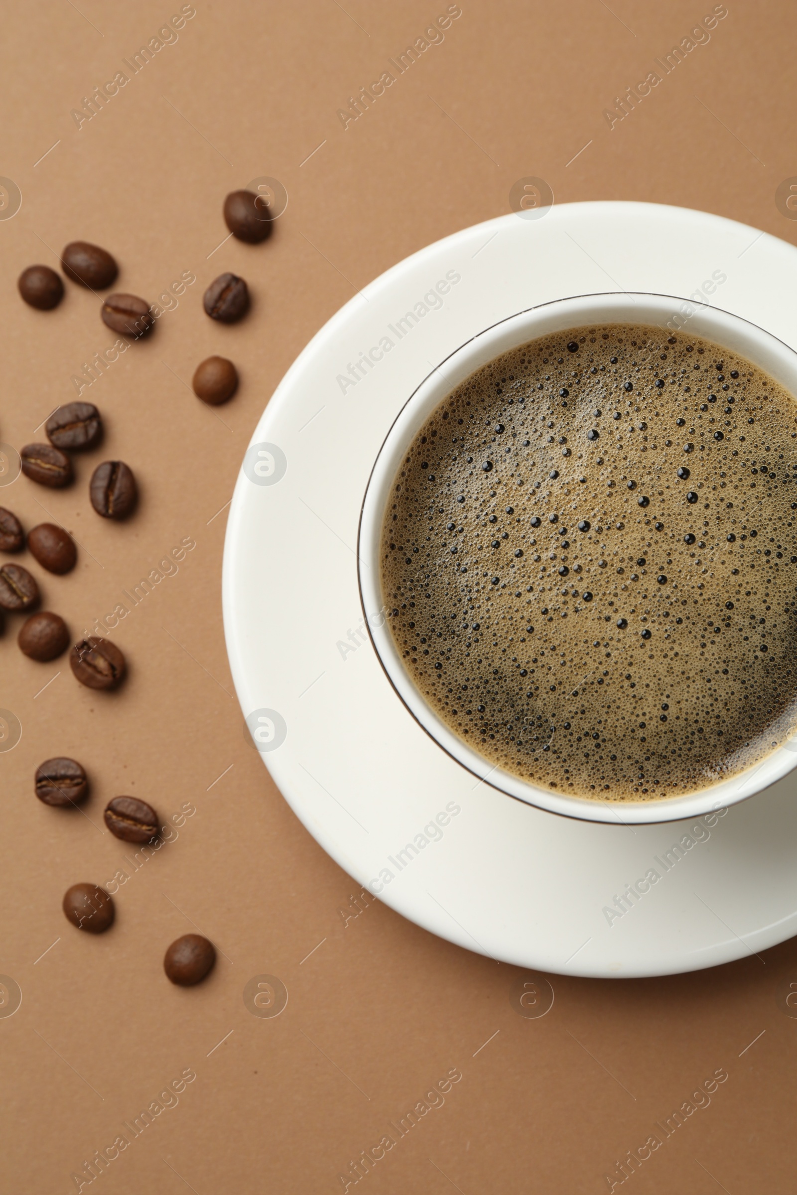 Aromatic coffee in cup and beans on beige background, flat lay Photo of Aromatic coffee in cup and beans on beige background, flat lay