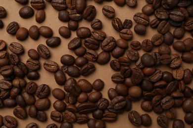 Photo of Aromatic coffee beans on beige background, flat lay