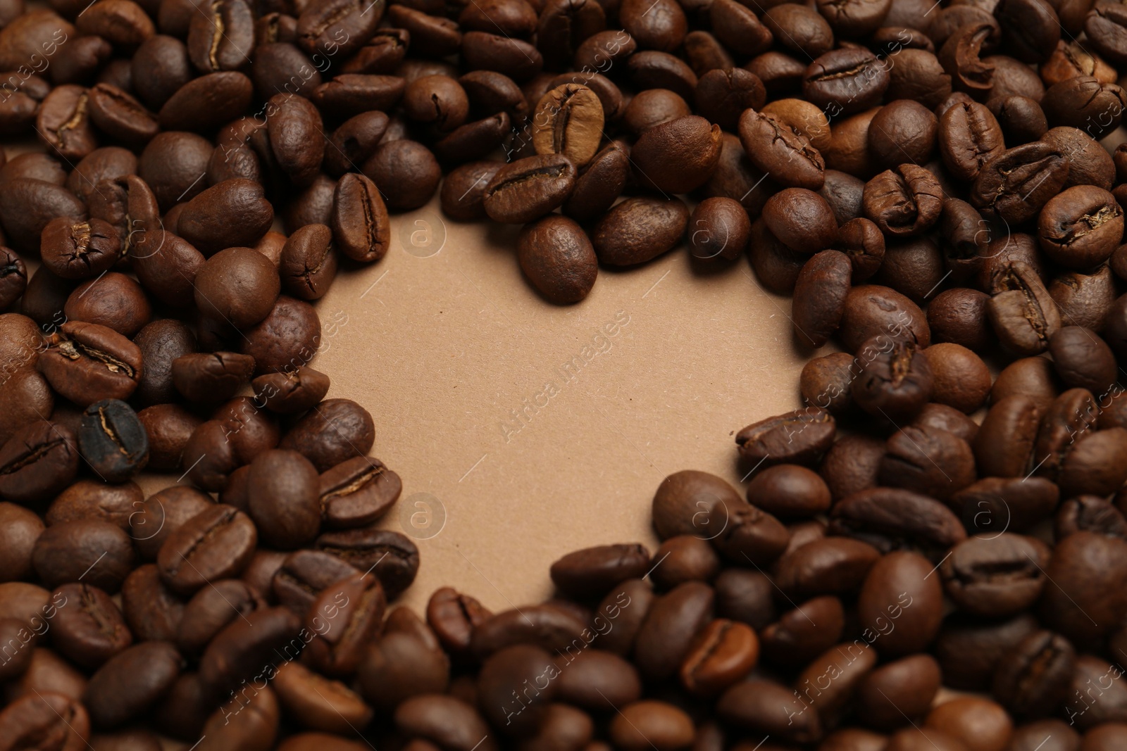 Heart shaped of coffee beans on beige background, closeup Photo of Heart shaped of coffee beans on beige background, closeup