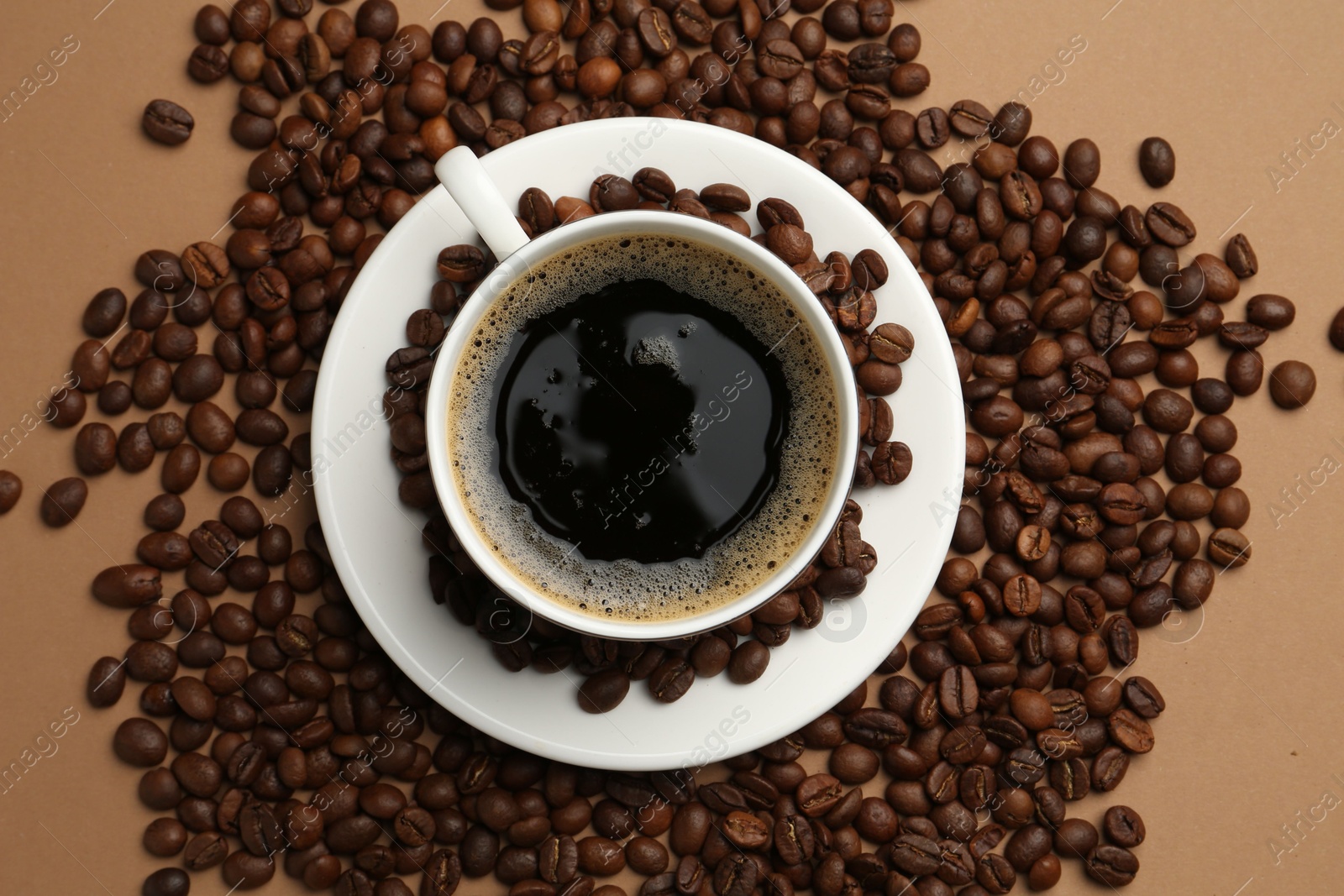 Aromatic coffee in cup and beans on beige background, flat lay Photo of Aromatic coffee in cup and beans on beige background, flat lay