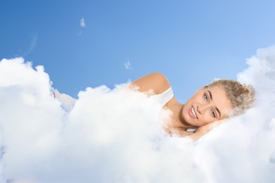 Image of Woman lying on fluffy cloud in blue sky. Bedtime