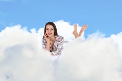 Image of Woman lying on fluffy cloud in blue sky. Bedtime