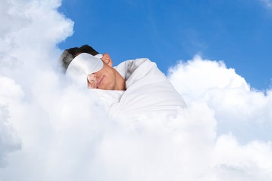 Image of Man with blanket and mask sleeping on fluffy cloud in blue sky. Bedtime