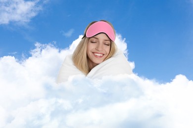 Image of Young woman with sleep mask and blanket on fluffy cloud in blue sky. Bedtime