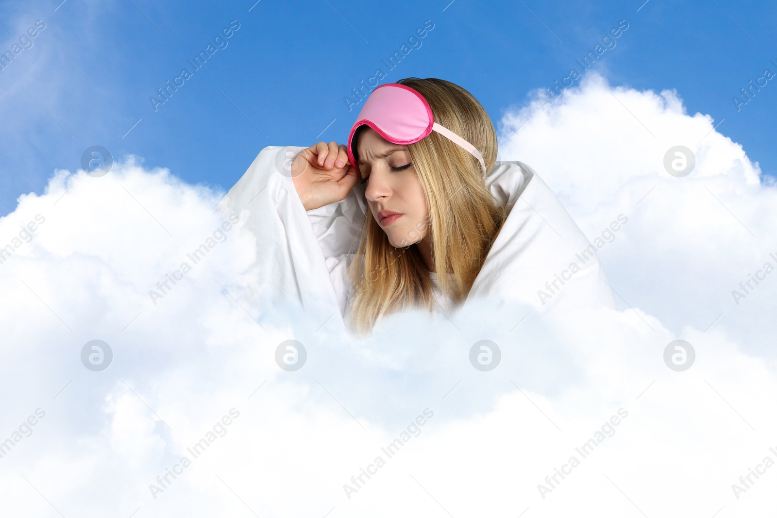 Young woman with sleep mask and blanket on fluffy cloud in blue sky. Bedtime Image of Young woman with sleep mask and blanket on fluffy cloud in blue sky. Bedtime
