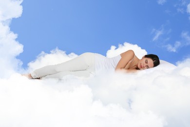 Image of Woman sleeping on fluffy cloud in blue sky. Bedtime