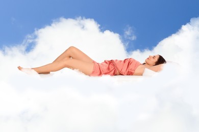 Image of Woman sleeping on fluffy cloud in blue sky. Bedtime
