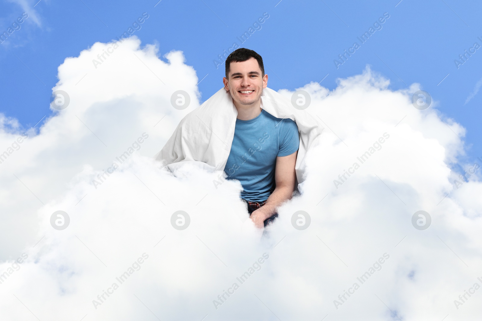 Happy man with blanket sitting on fluffy cloud in blue sky. Bedtime Image of Happy man with blanket sitting on fluffy cloud in blue sky. Bedtime