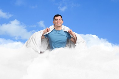 Image of Happy man with blanket sitting on fluffy cloud in blue sky. Bedtime
