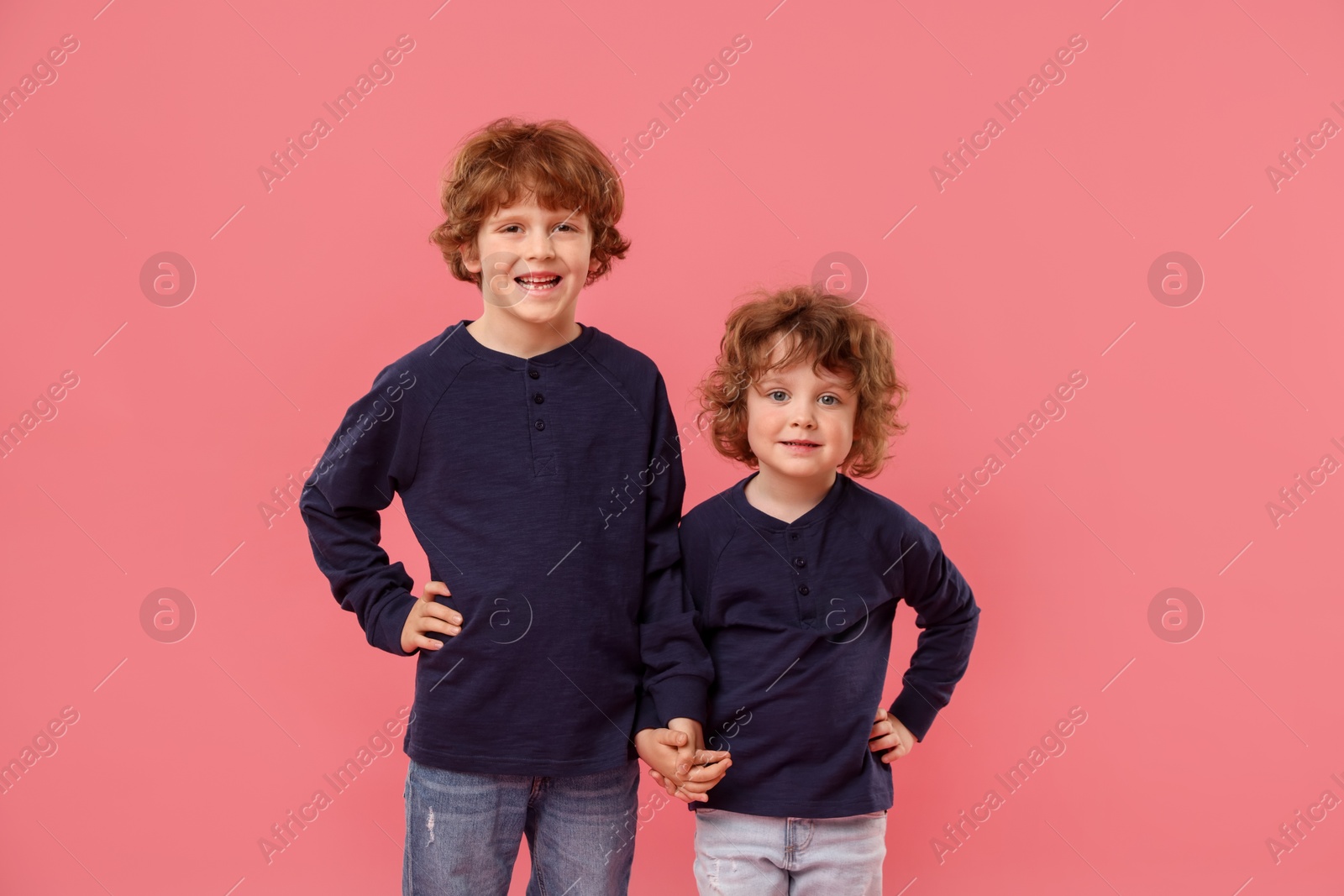 Cute little brothers together on pink background Photo of Cute little brothers together on pink background