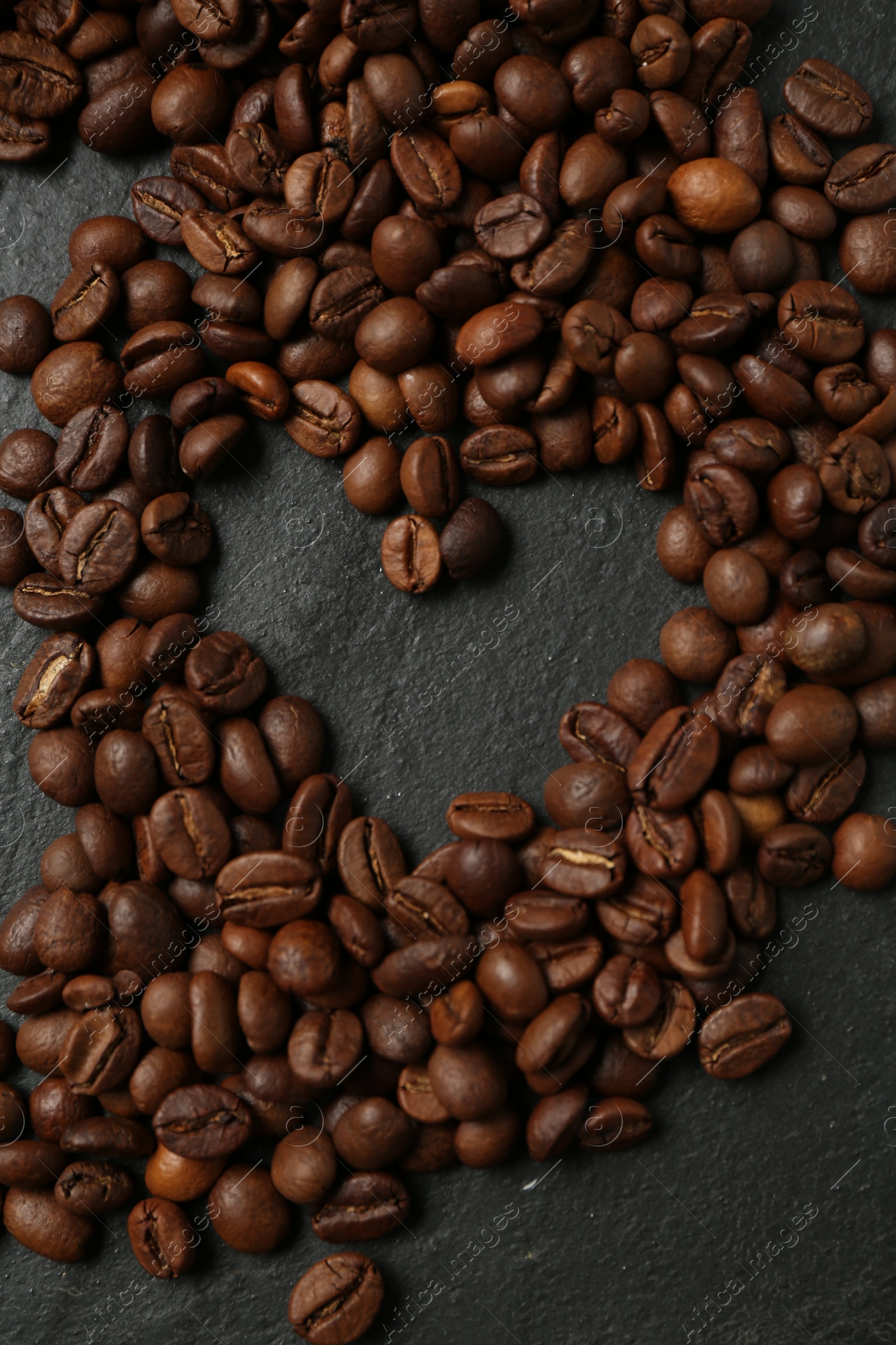 Heart shaped of coffee beans on black table, flat lay Photo of Heart shaped of coffee beans on black table, flat lay