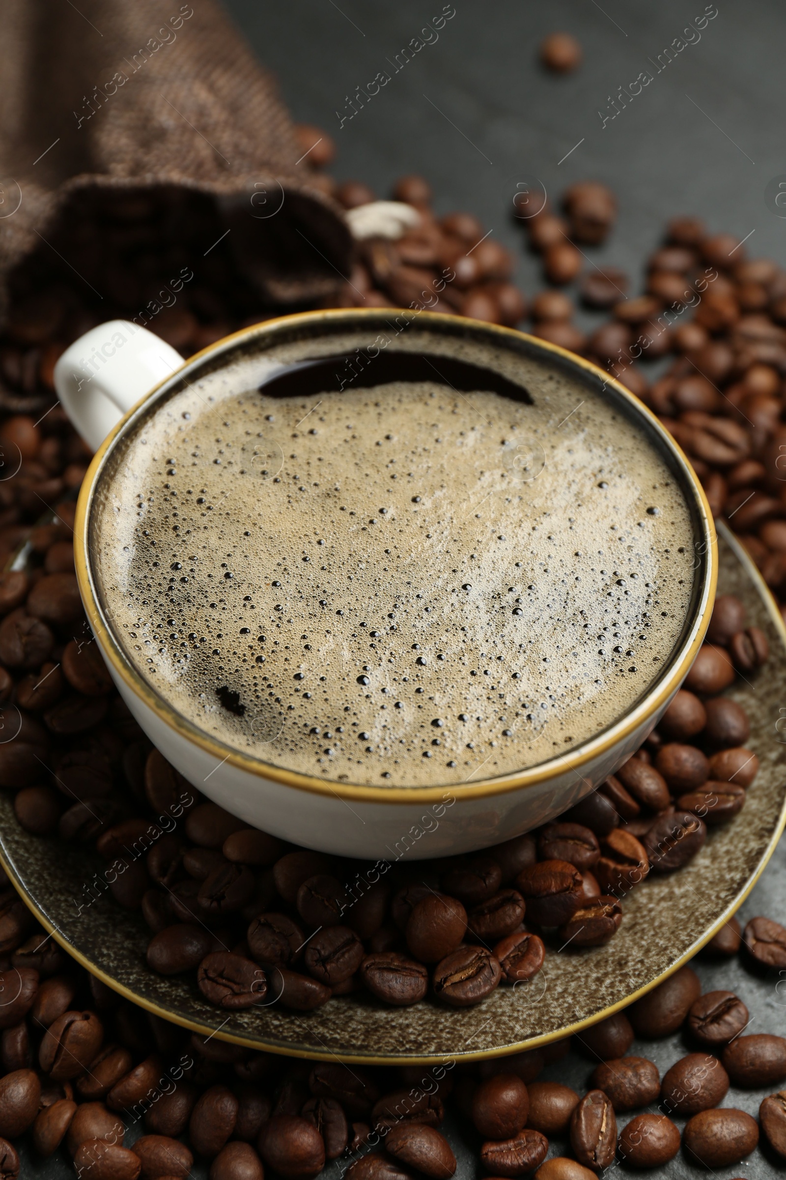 Aromatic coffee in cup and beans on table, closeup Photo of Aromatic coffee in cup and beans on table, closeup