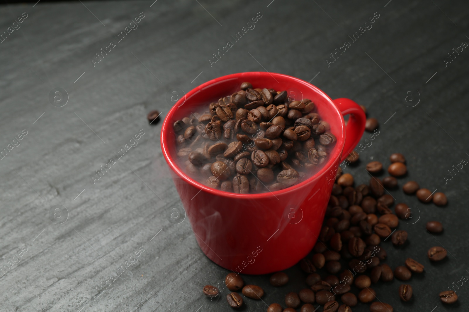 Aromatic coffee beans in cup on black table, closeup. Space for text Photo of Aromatic coffee beans in cup on black table, closeup. Space for text