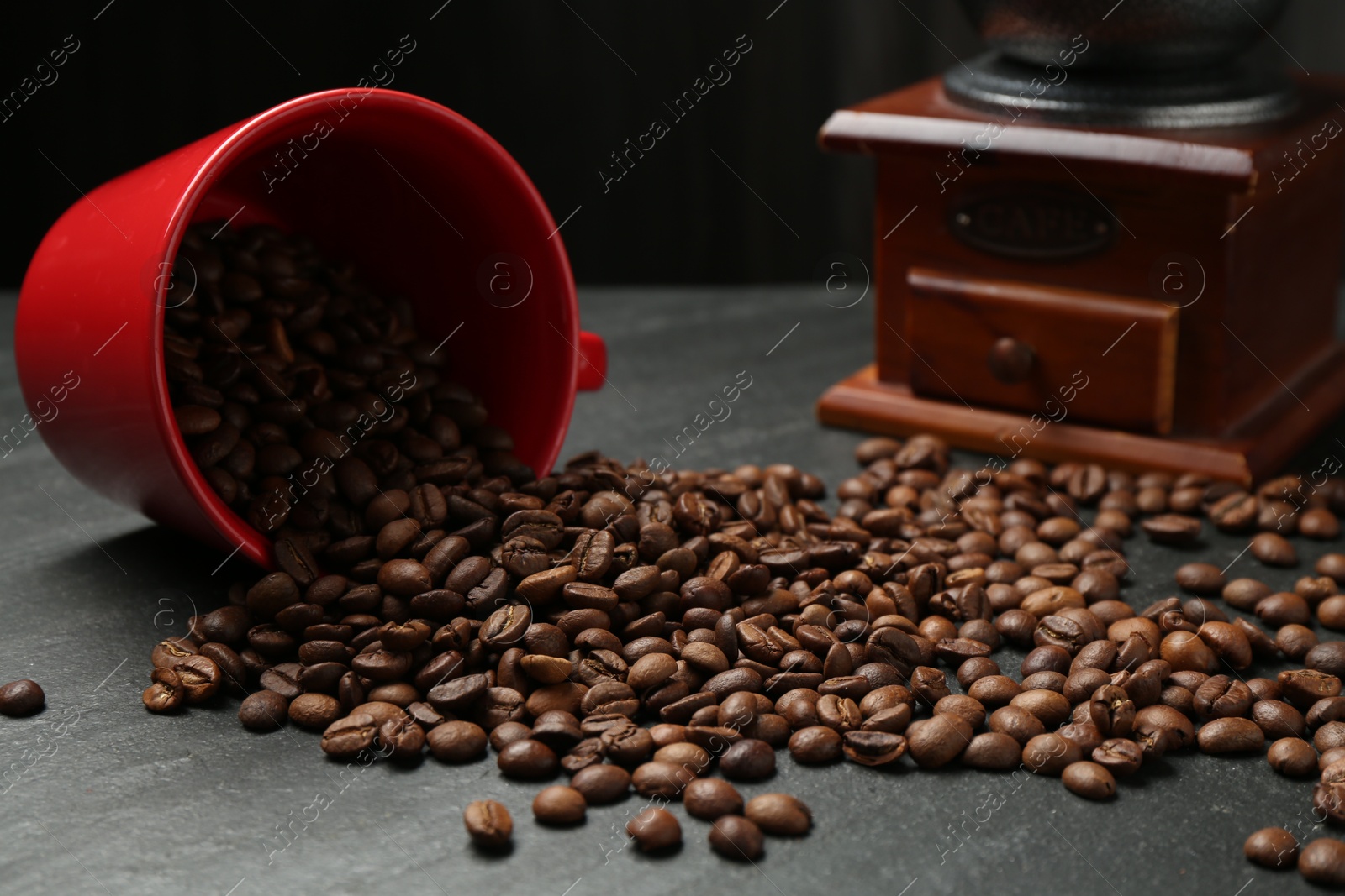 Aromatic coffee beans and grinder on black table, closeup Photo of Aromatic coffee beans and grinder on black table, closeup