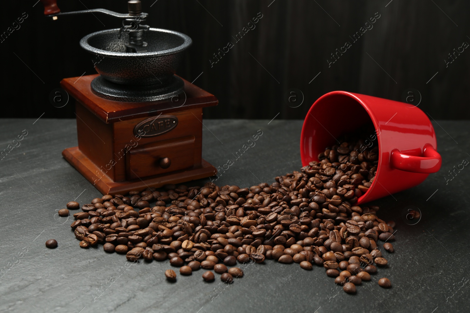 Aromatic coffee beans and grinder on black table Photo of Aromatic coffee beans and grinder on black table