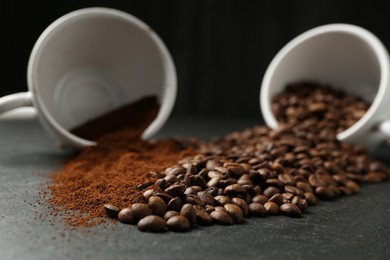 Photo of Aromatic ground coffee and beans on black table, closeup