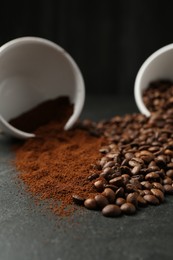 Photo of Aromatic ground coffee and beans on black table, closeup