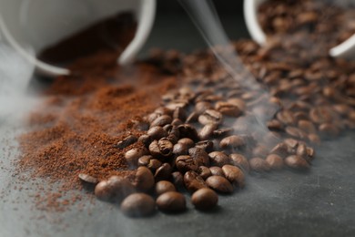 Photo of Aromatic ground coffee and beans on black table, closeup