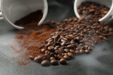 Photo of Aromatic ground coffee and beans on black table, closeup
