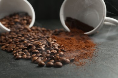Photo of Aromatic ground coffee and beans on black table, closeup